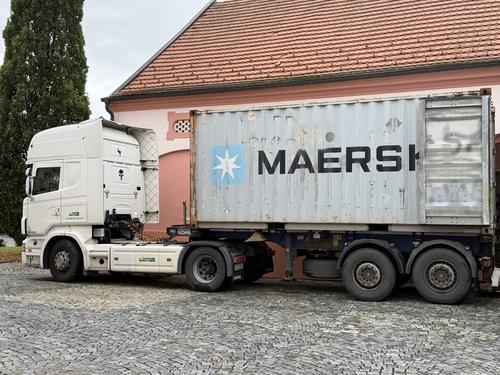 Tahač s kontejnerem na dvoře